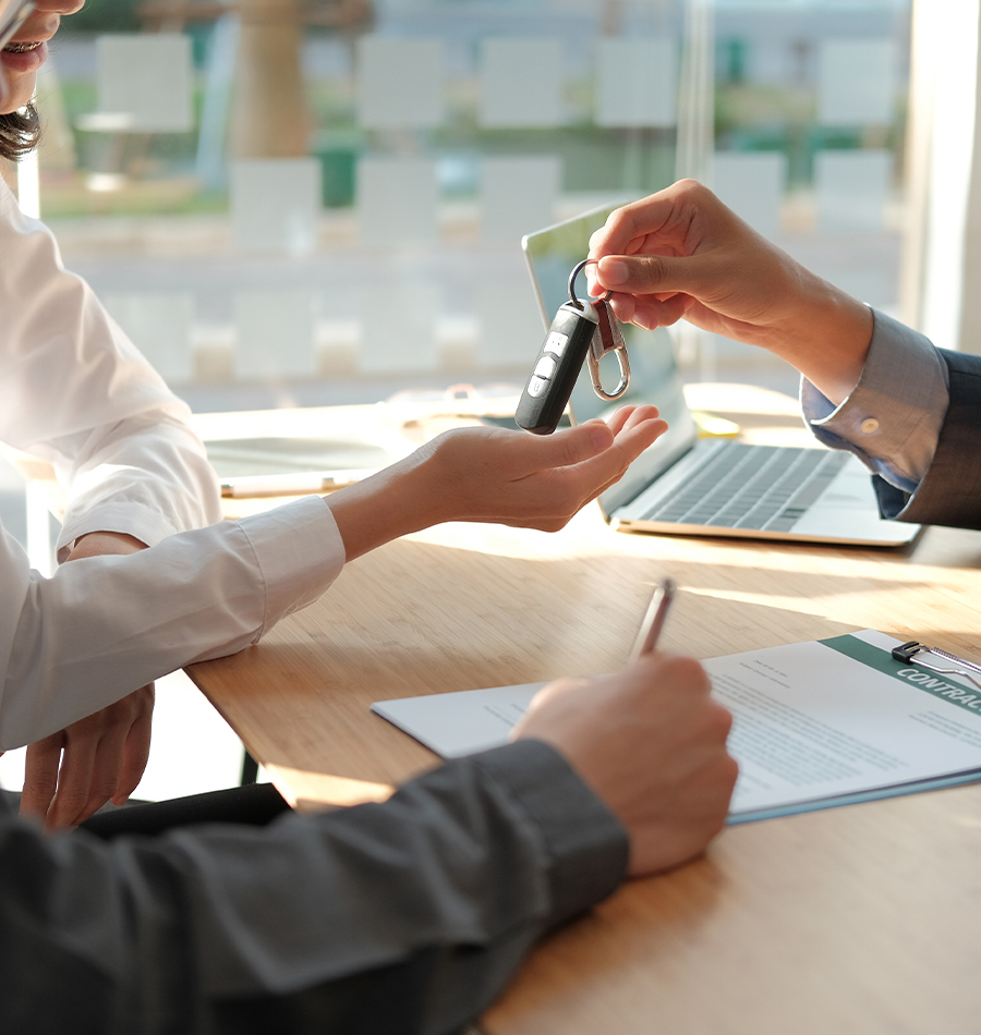 car keys being handed over at a car dealership office